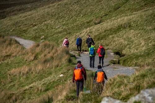 Group of walkers hiking along the Llanberis Path towards Yr Wyddfa in Eryri
