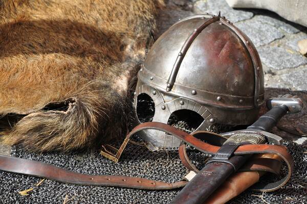 Black steel helmet near black and gray handle sword 161936